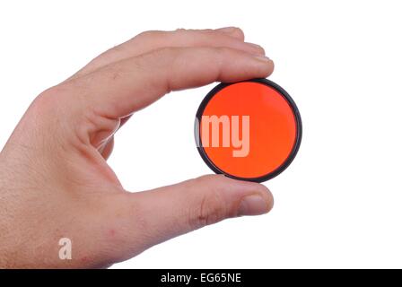 man hand holds a red photographic filter, isolated on white background Stock Photo