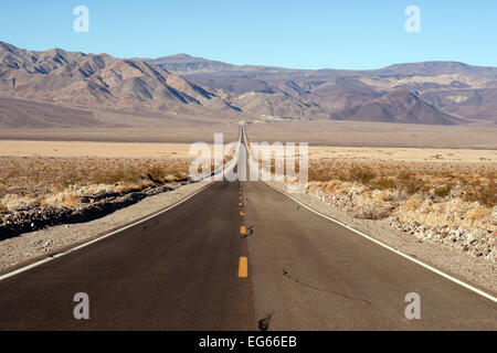 The road dips down allowing long visabilty in Death Valley Stock Photo