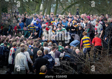 Ashbourne,Derbyshire,UK.17th February 2015. The annual two day shrovetide football game got underway today with Mr Mick Pepper having the honour of ' Turning up the ball' at 14.00pm . Local men have taking part in this historic game for over 900 years ,If your born North of the river Henmore then your a Up'ard and south your a Down'ard .Shrovetide player dives for ball has it leaves the hug and in to the river Henmore. Credit:  IFIMAGE/Alamy Live News
