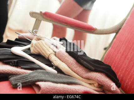 lying on a armchair various knitting sweaters for try Stock Photo