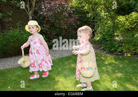 Girl toddler on Easter egg hunt with basket for eggs, release may be available fer certain uses Stock Photo