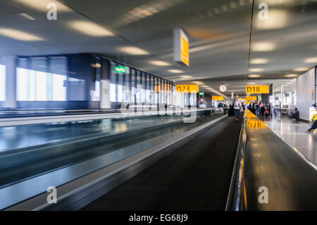 People on a moving walkway at an airport, blurred to show movement and speed. Stock Photo