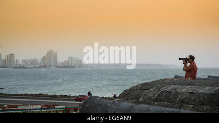 Cartagena, Colombia - February 23, 2014 - A photographer shoots the skyline of Cartagena from the old city walls as the sunsets  Stock Photo