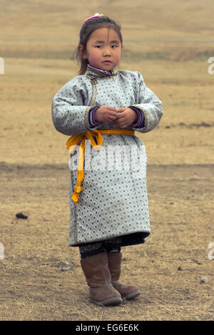 Young Mongolian girl in traditional costume (deel) with her goat ...