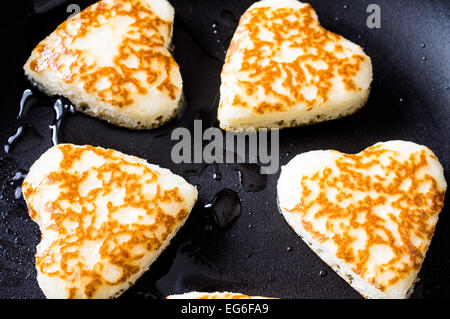 Pancakes in the form of hearts on a frying pan Stock Photo