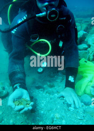 Jerusalem. 17th Feb, 2015. An undated photograph supplied by the Israeli Antiquities Authority on Feb. 17, 2015 shows a diver displaying the largest hoard of gold coins ever found in Israel. A fortune of at least 2,000 ancient gold coins were discovered accidentally by scuba divers offshore Israel about two weeks ago, the Israel Antiquities Authority said on Tuesday. It was found on the seabed in the ancient harbor of Caesarea National Park, the Antiquities Authority said in a statement. © JINI/Hand Out/Israel Antiquities Authority/Xinhua/Alamy Live News Stock Photo