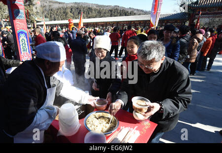 Beijing, China. 18th Feb, 2015. Visitors get free food during a traditional blessing ceremony in the Badachu Park in Beijing, capital of China, Feb. 18, 2015. The ceremony was the prelude to the new year temple fair which will be officially open to public on Feb. 19. Credit:  Li Jundong/Xinhua/Alamy Live News Stock Photo