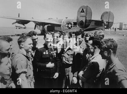 Soviet (Russian) World War 2 ace Mikhail Avdeev with American pilots. In the background is a Consolidated B-24 Liberator Stock Photo