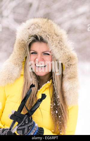 Blonde young smiling woman with ski at winter time. Fair caucasian girl have fun with skiing Stock Photo