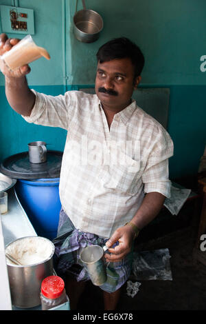 'Chai wallah' or tea maker - tea man pours his chai between glasses before serving to customers, Kumily, Kerala, Southern India Stock Photo