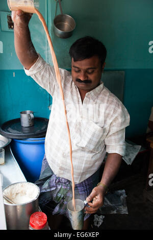 'Chai wallah' or tea maker - tea man pours his chai between glasses before serving to customers, Kumily, Kerala, Southern India Stock Photo