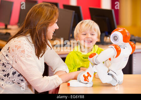 One young boy programming a robot with his science teacher on a primary school Stock Photo