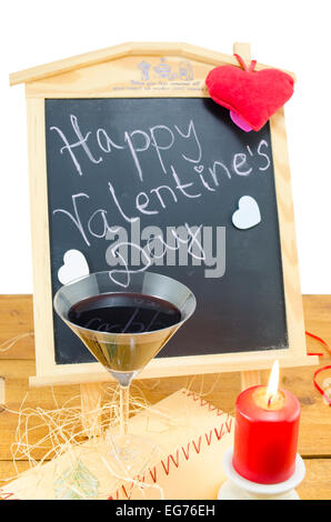 Blackboard with the words Happy Valentines written on it, decorated with hearts, a candle and a wine glass Stock Photo