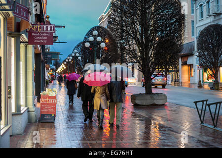 People walking downtown on rainy night-Victoria, British Columbia, Canada. Stock Photo