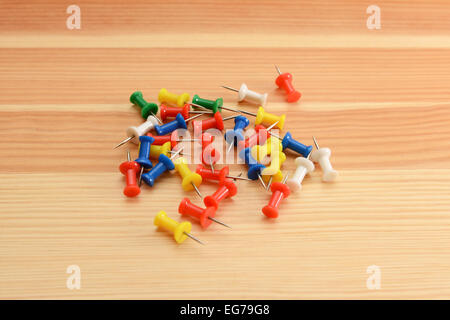 Coloured push pins - green, white, red, yellow and blue - on a wooden background Stock Photo