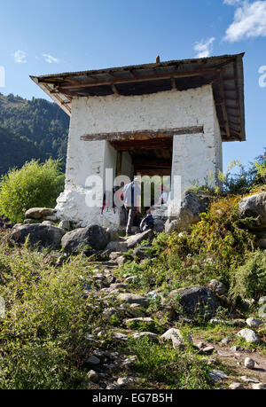 BHUTAN - Hikers on the Jhomolhari 2 Trek taking a break in an archway built to honor the Divine Madman in the Paro Chhu valley. Stock Photo