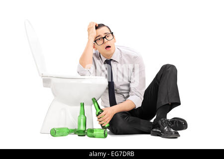 Drunk guy leaning on a toilet seat isolated on white background