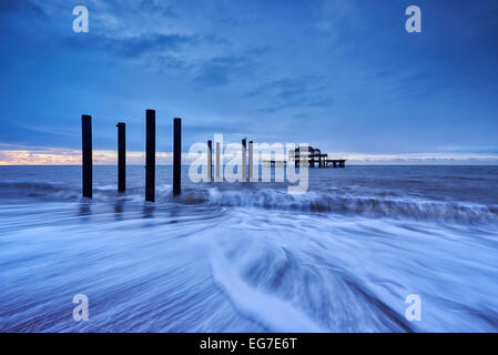 The decaying remains of Brighton's West Pier at sunrise with the tide coming in. Stock Photo