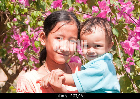 Young girl with small child on the arm, Phu Quoc, Vietnam, Asia Stock Photo