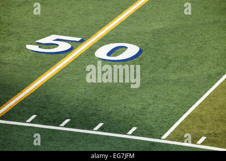 An overhead view of the middle of an American football field, showing the 50 yard marker. Stock Photo
