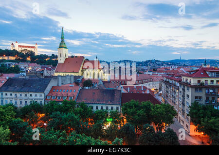 Overview of old town at dusk with lit up cathedral and castle. Bratislava, Slovakia Stock Photo