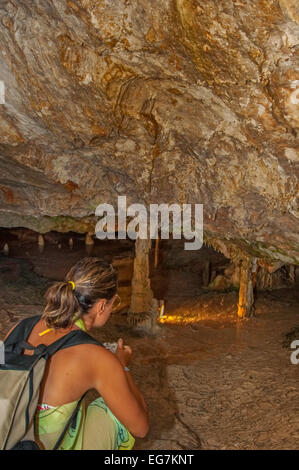 Woman admiring stalactites in cave Stock Photo