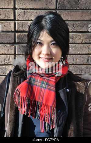 Japanese woman wearing tartan scarf, England, UK Stock Photo