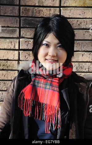 Japanese woman wearing tartan scarf, England, UK Stock Photo