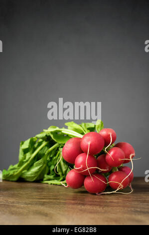 A bunch of fresh radishes on wooden table Stock Photo