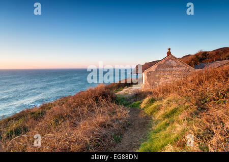 An old abandoned cottage set in an idyllic location on cliffs above Lantivet Bay on the south Cornwall coast Stock Photo