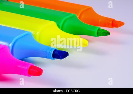 Highlighter pens with caps removed against a white background. Stock Photo