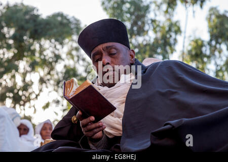 A Christian Priest Reading His Bible At Bete Maryam Church At Christmas Time, Lalibela, Ethiopia Stock Photo