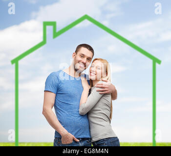 smiling couple hugging over green house Stock Photo