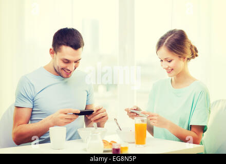 smiling couple with smartphones taking picture Stock Photo