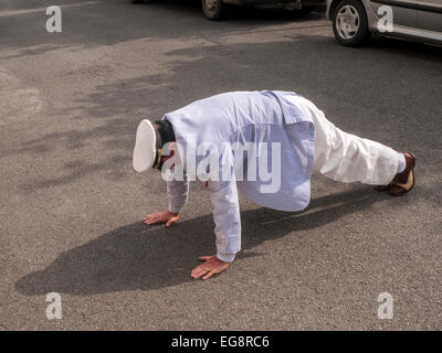 Well-dressed man doing push-ups in street - France. Stock Photo