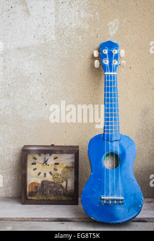 Ukulele leaning against the wall. Stock Photo