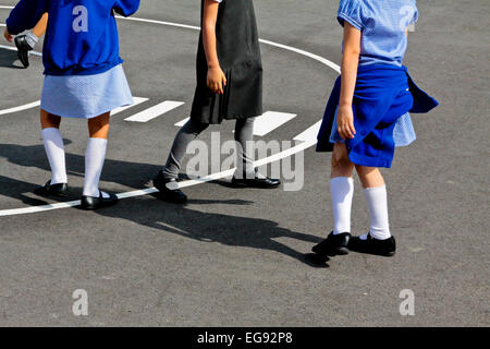 Primary schoolchildren playing in a school playground at break time with games marked out on the asphalt surface Stock Photo