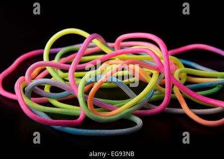 Bright multicolored neon para cord glowing against black background Stock Photo
