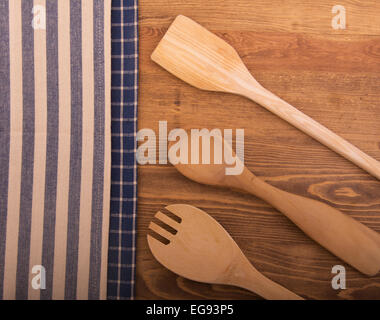 Classic kitchen towels and wooden utensils on dark wood tabletop Stock Photo