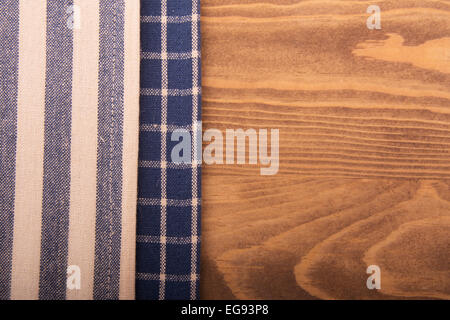 Blue and off white kitchen towels on wooden table Stock Photo