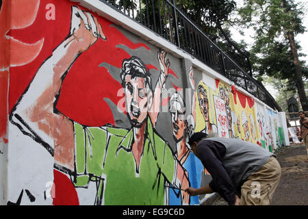 Dhaka, Bangladesh, 20th Feb, 2015. Bangladeshi fine arts student paints on the wall as part of the decoration for the International Mother Language Day celebration Stock Photo