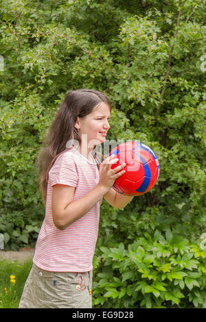 Girl kid playing with soccer ball in the garden Stock Photo