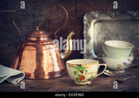 Vintage kettle and tea cups on wooden table Stock Photo