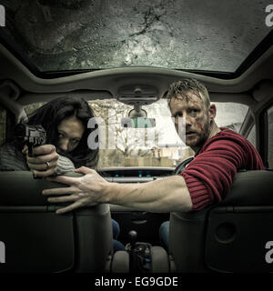 Couple in car with gun Stock Photo