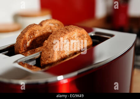 Electrical toaster in kitchen with cooked toast made from brown bread Stock Photo