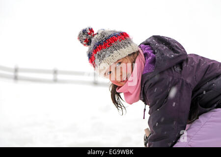 pretty little girl with wool beret playing on snow in the mountains Stock Photo