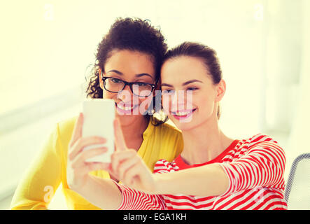 girlfriends taking selfie with smartphone camera Stock Photo