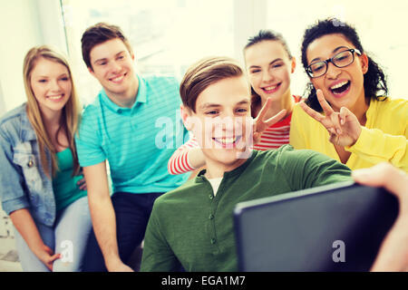 smiling students making selfie with tablet pc Stock Photo