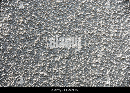 Abstract of rough pebble-dashed wall in glancing sunshine Stock Photo