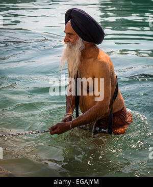 An old Sikh man takes to the holy water of The Golden Temple, Amritsar, Punjab, India Stock Photo